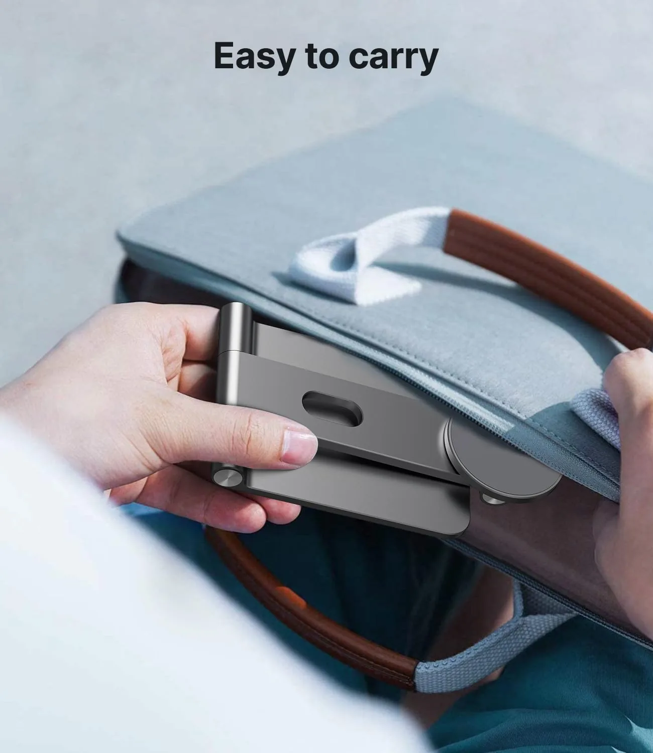 Hands sliding a folded SiWiQU aluminium console stand into a grey felt laptop sleeve